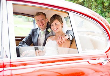 Leaving the wedding ceremony in wedding car.