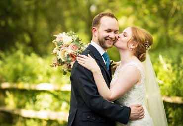 Bride kissing husband wedding photo